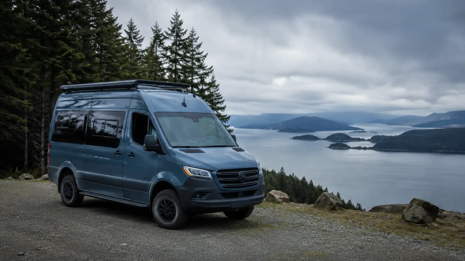 A camper van parked at a viewpoint overlooking water and islands