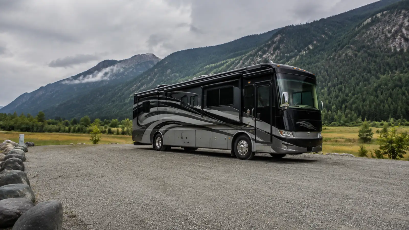 A large Class A motorhome parked at a wide open campground site