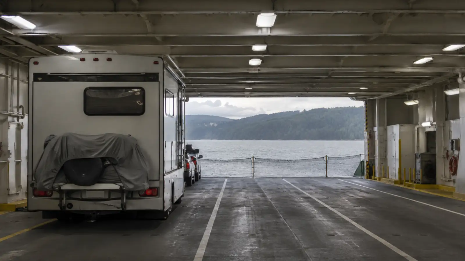 A motorhome waiting in a marked lane on a ferry vehicle deck