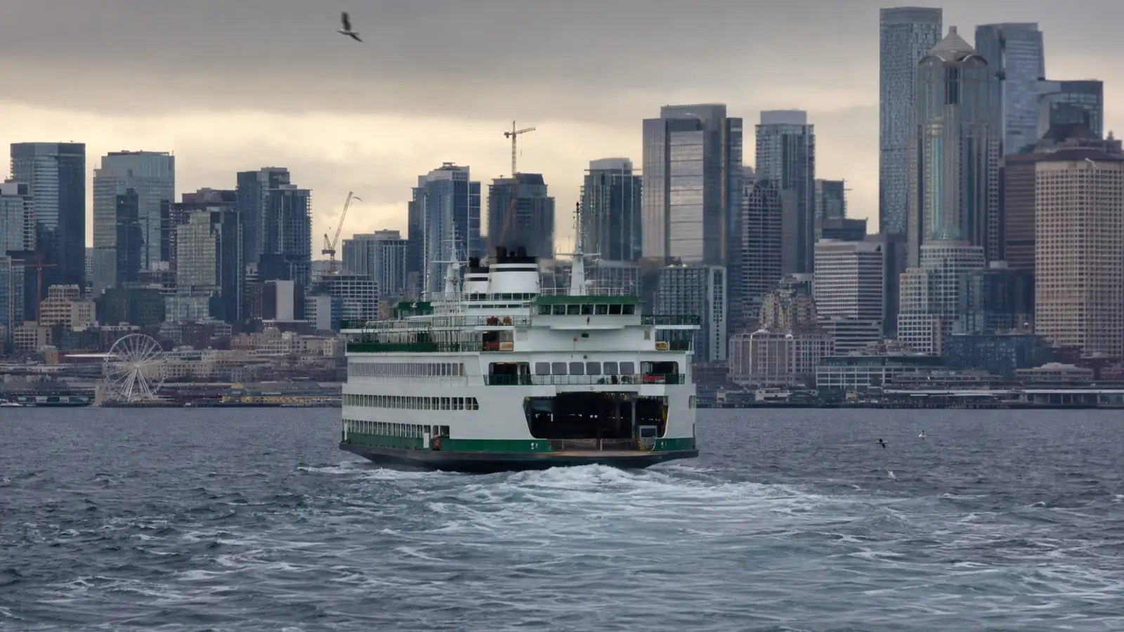A ferry crossing Elliott Bay with the Seattle waterfront behind it