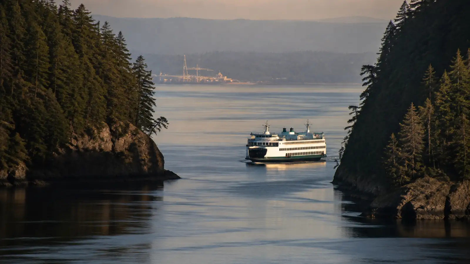 A ferry passing through a narrow forested passage on a long crossing